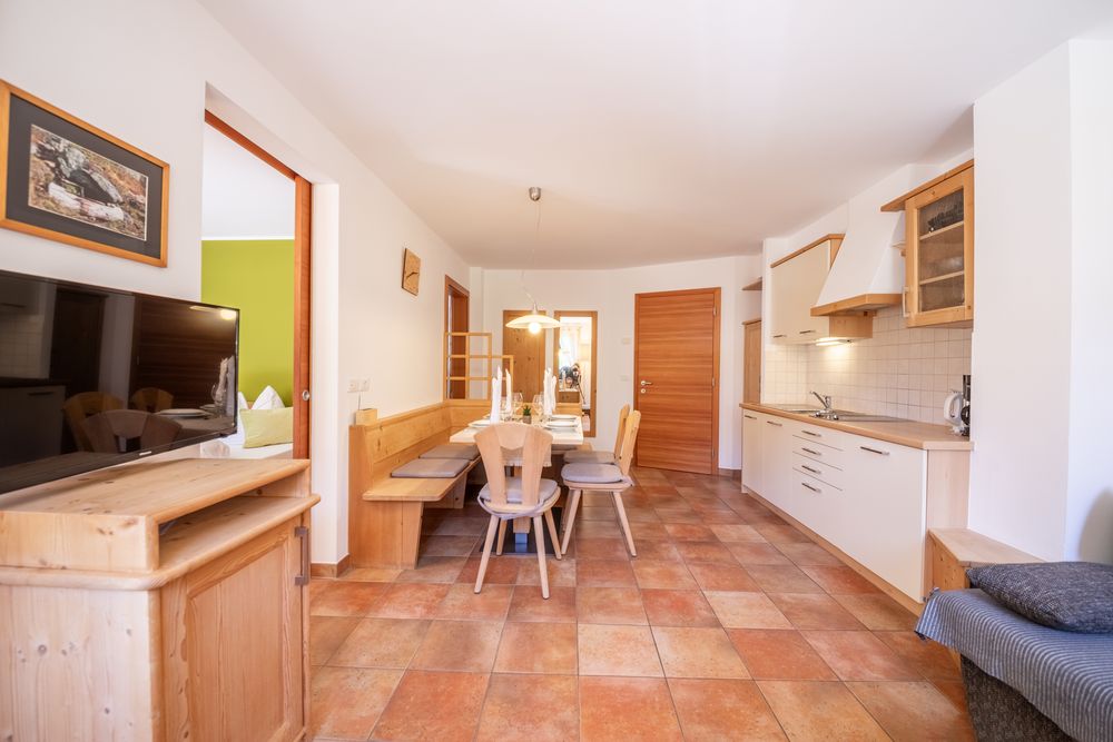 An open living area with a dining space and kitchenette in a rustic style.