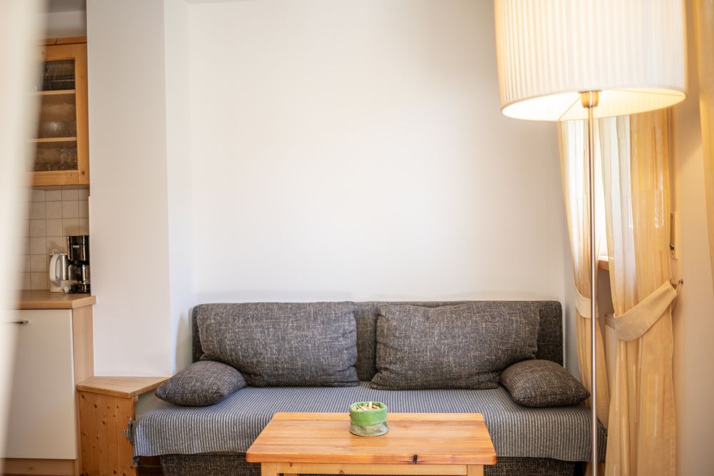 A gray sofa with a wooden table in front of it in a cozy living area.